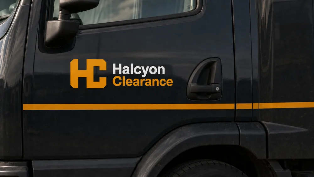 Cab door in Halcyon Clearance livery: amber HC mark beside the stacked Halcyon Clearance wordmark, with an amber band running along the door.